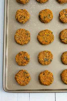 Sheet pan filled with sweet potato patties lined up on the sheet pan