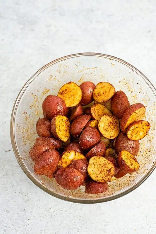 Baby potatoes coated in cajun seasoning in a bowl.