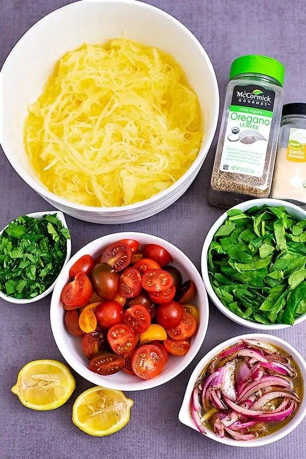 Ingredients for Greek Spaghetti Squash Salad on a concrete background.