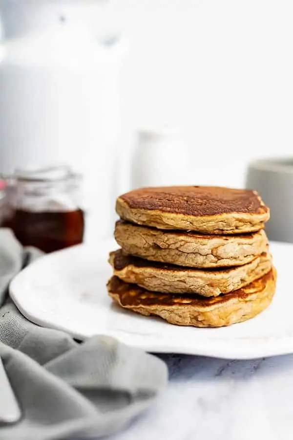 Large stack of gluten free protein pancakes on a white plate 