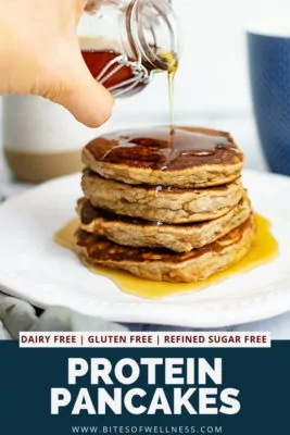 Hand pouring syrup over gluten free protein pancakes