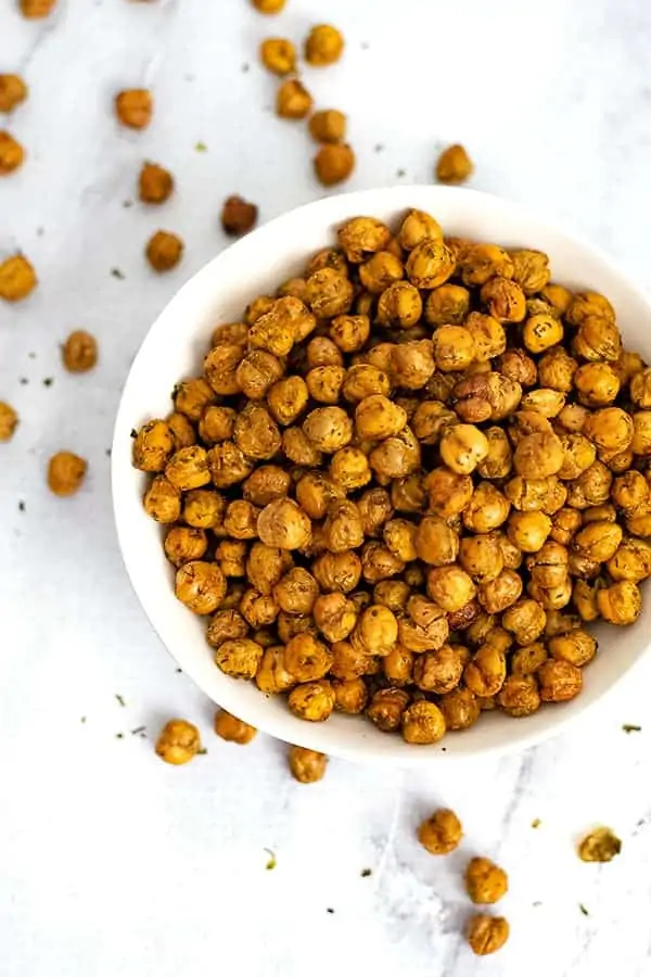 white bowl filled with ranch roasted chickpeas with chickpeas in the background