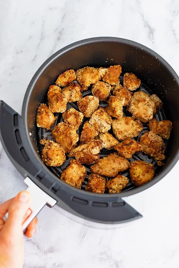 Air fryer basket filled with air fryer chicken nuggets