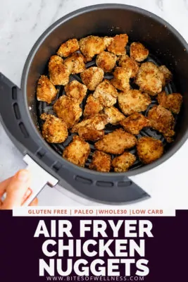Air fryer basket filled with air fryer chicken nuggets. Pinterest text on the bottom