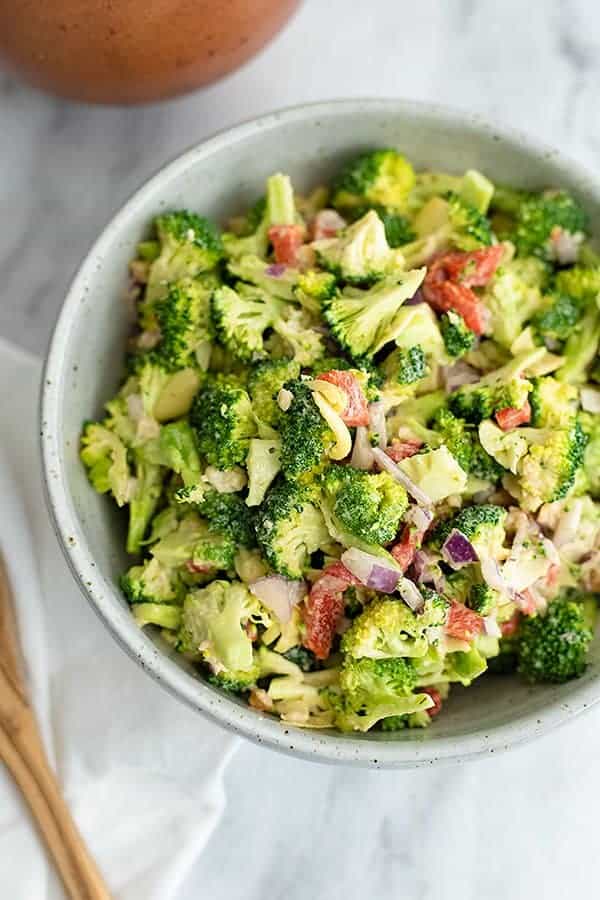 Large bowl filled with crunchy broccoli salad over a white napkin