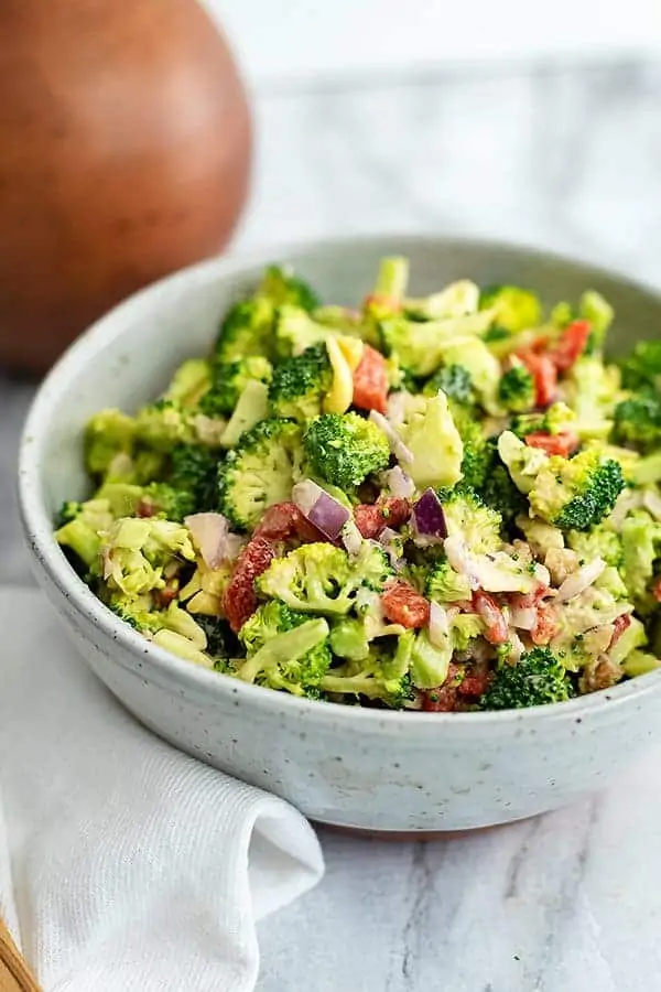 Large bowl filled with crunchy broccoli salad with lemon tahini dressing