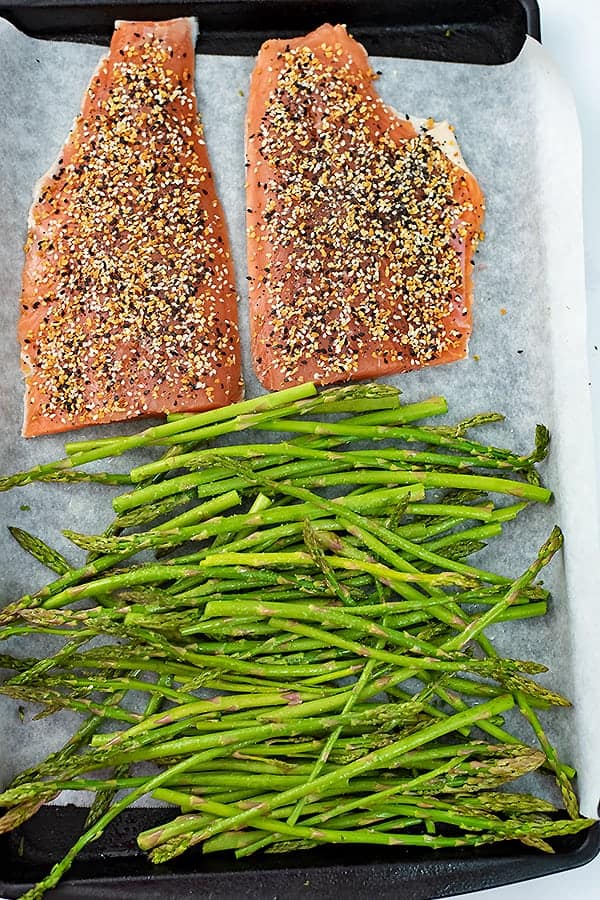 Everything bagel salmon on a sheet pan with asparagus before cooking