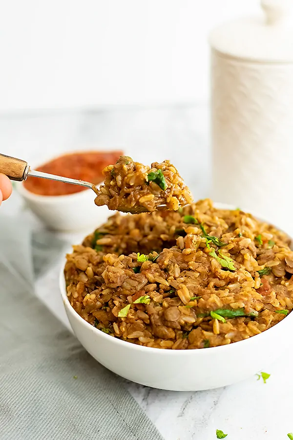 Spoonful of lentil and rice mixture being scooped from the bowl