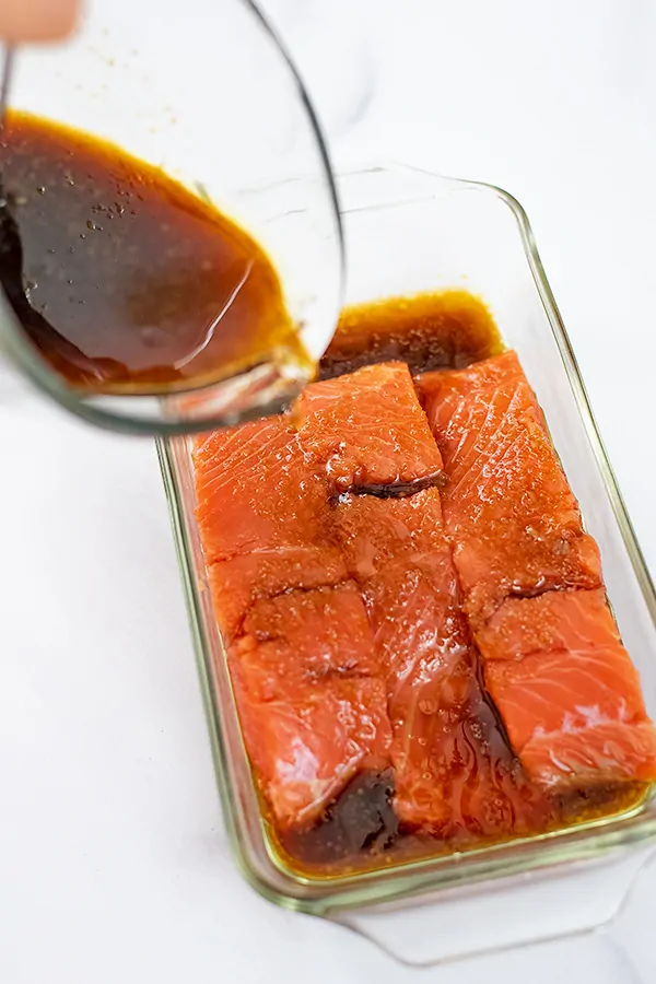 Teriyaki sauce being poured over salmon