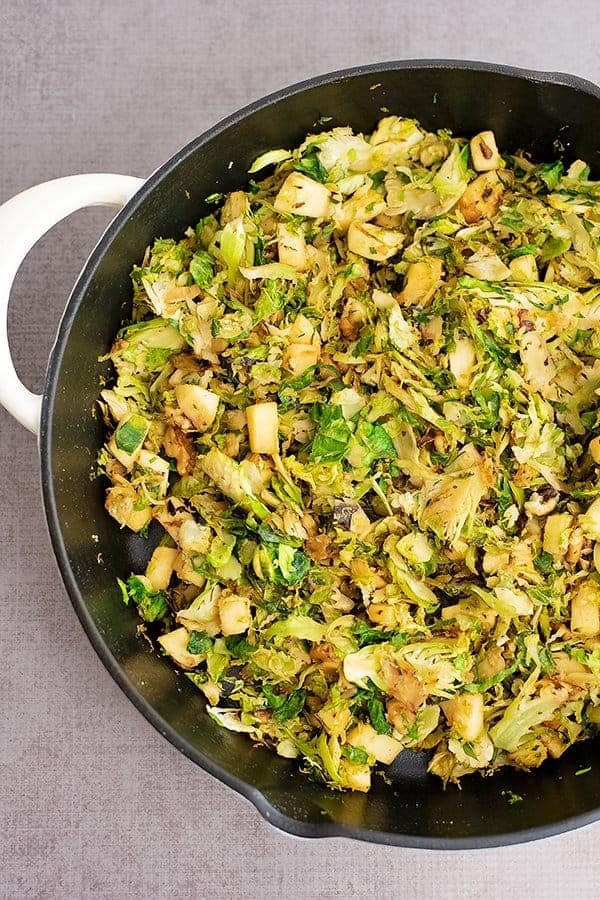 Large cast iron skillet filled with Apple Brussel Sprouts Hash 