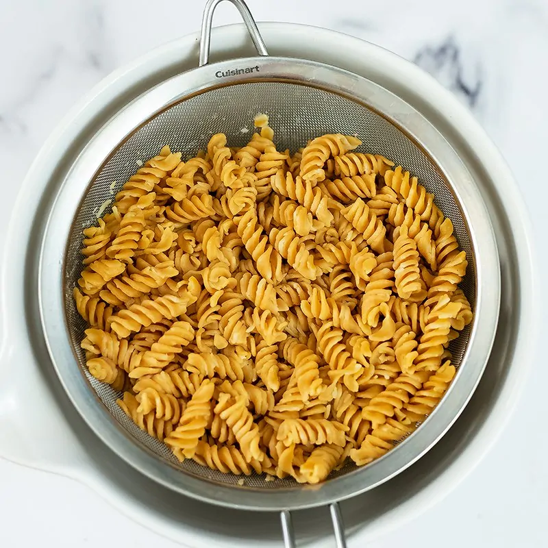 Cooked pasta in a colander. 