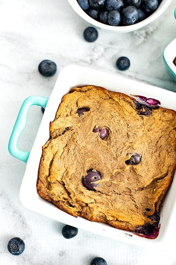 Single serve blueberry banana bread surrounded by blueberries