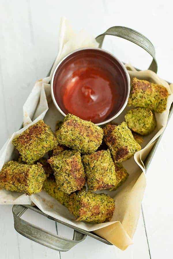 Tray full of broccoli tots with a side of ketchup.