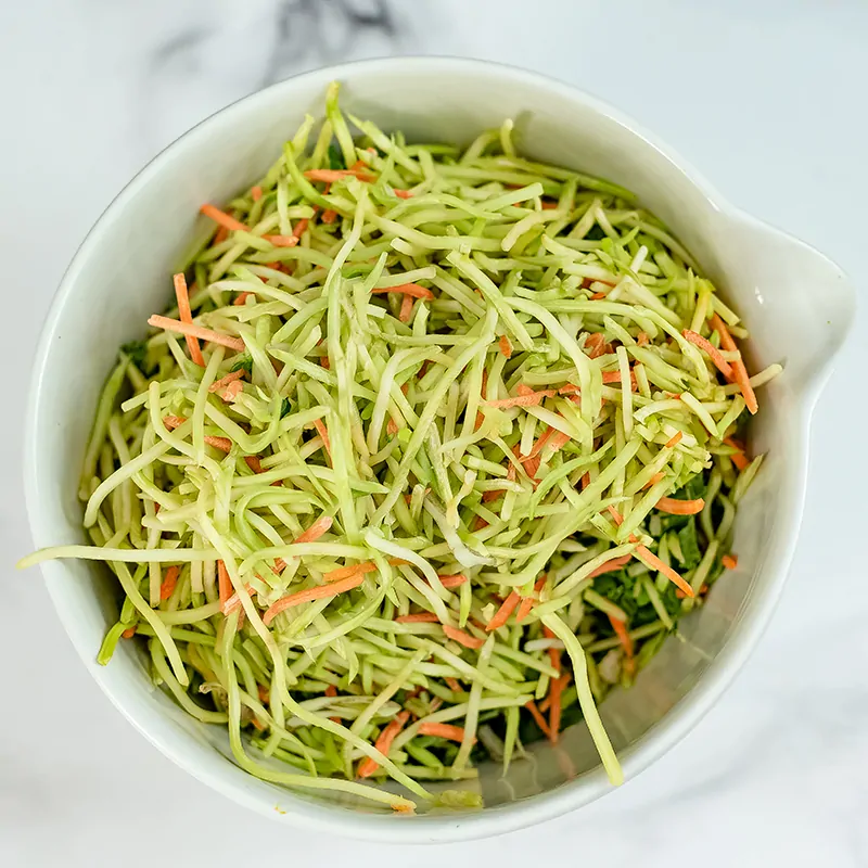 Broccoli slaw in a large white bowl