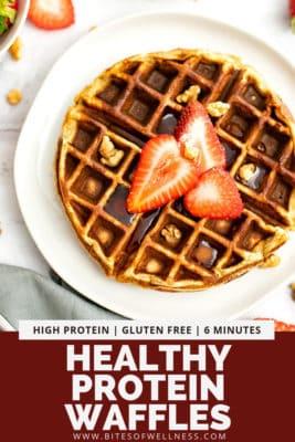 Gluten free protein waffles with syrup and strawberry slices on a white plate.