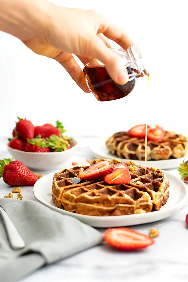 Syrup being poured over protein waffles 