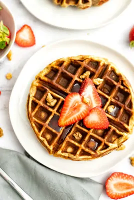 Protein waffle with sliced strawberries and chopped walnuts on top
