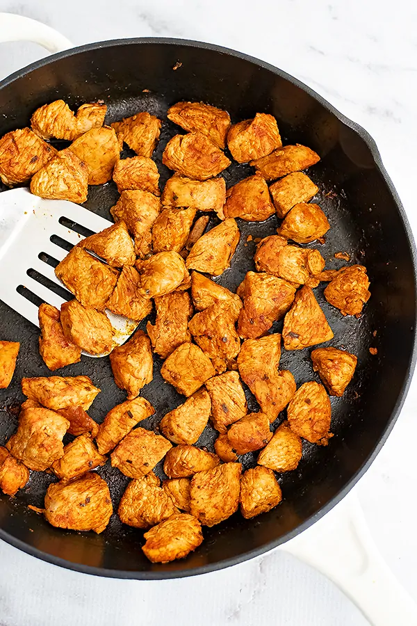 Cast iron skillet filled with taco chicken meat