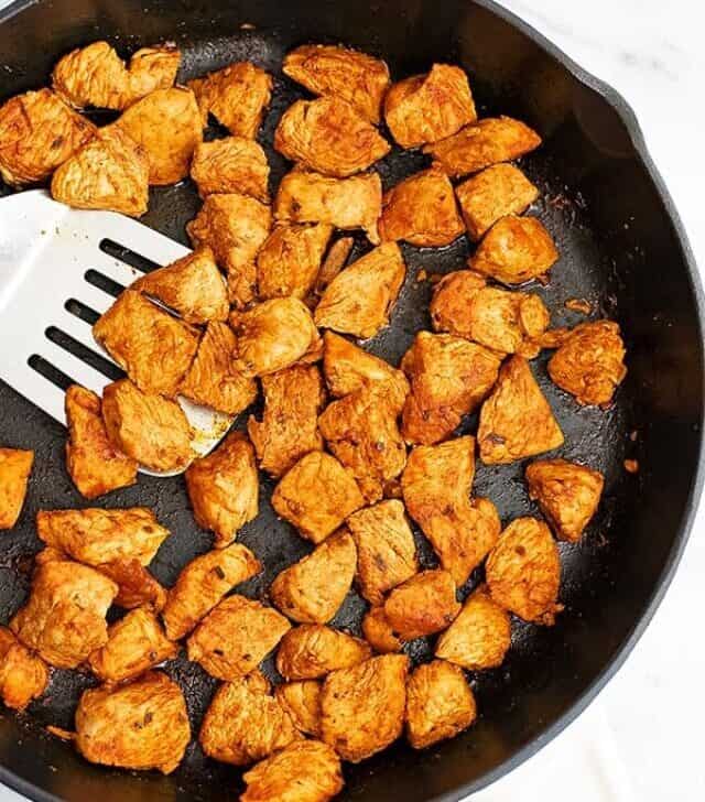 Cast iron skillet filled with taco chicken meat