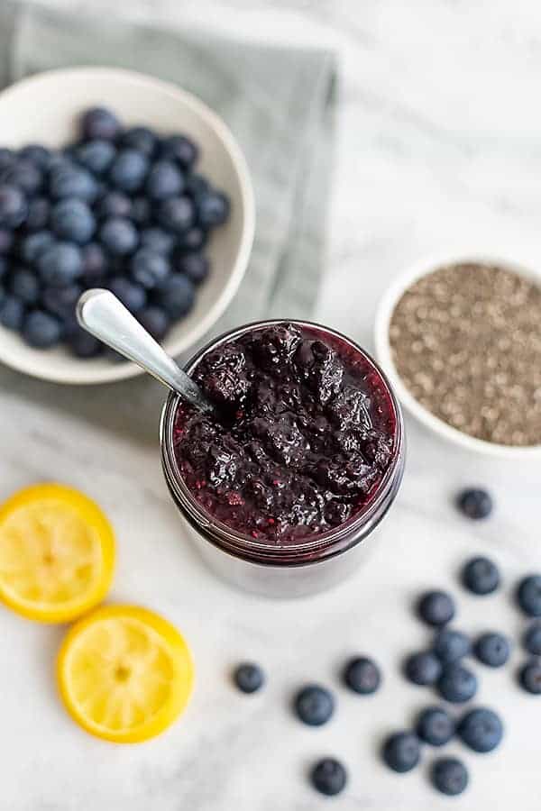 Jar of blueberry chia jam with a spoon in the jar