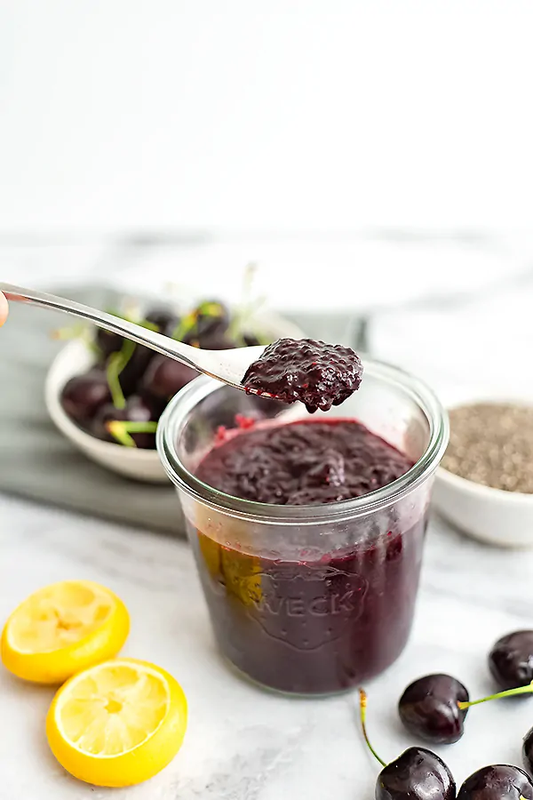 Cherry Chia Jam with a spoon holding a scoop of jam