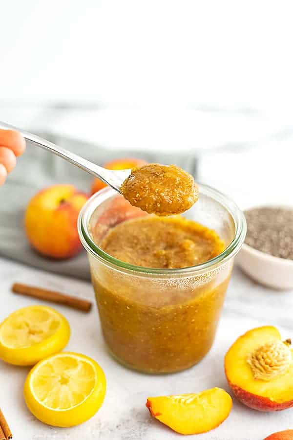Cinnamon Peach Chia Jam with a spoon holding a scoop of jam