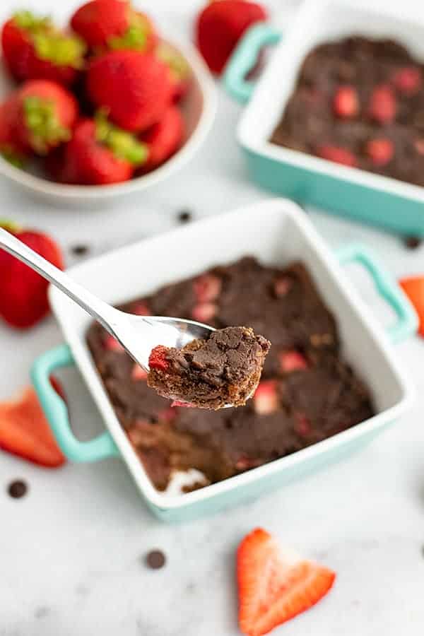 Spoonful of a chocolate brownie with strawberries