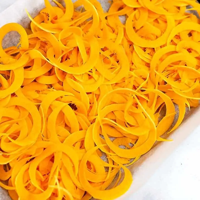 Butternut squash noodles on baking sheet before baking.