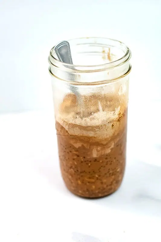 Protein powder added to jar of overnight oats.