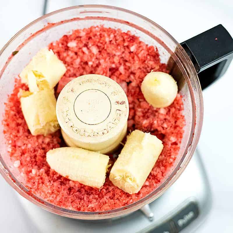 Bananas added to pulsed frozen strawberries in food processor