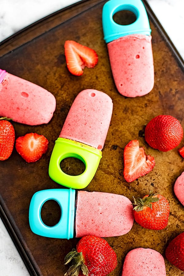Tray of strawberry popsicle and sliced strawberries