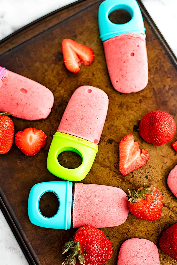 Tray of strawberry popsicle and sliced strawberries