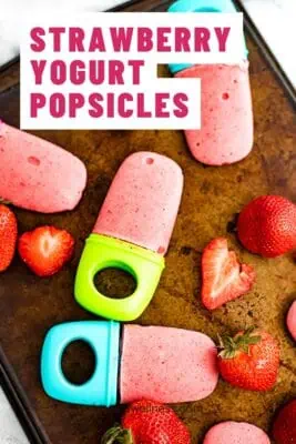 Strawberry yogurt popsicles on a sheet pan.