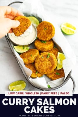 Hand dipping curry salmon cake in yogurt sauce