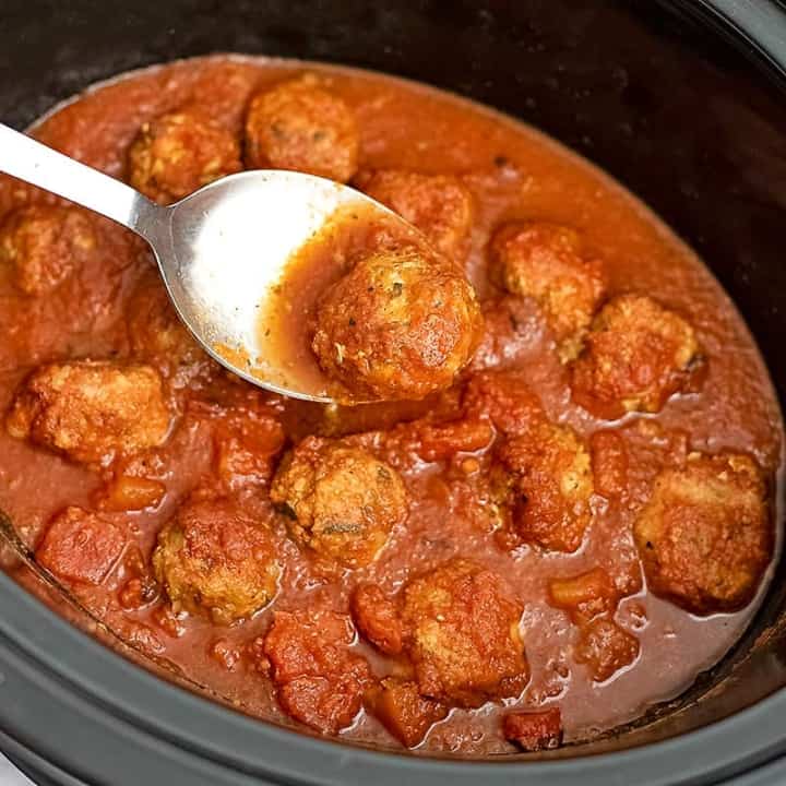 Crockpot of Whole30 slow cooker turkey meatballs with silver serving spoon