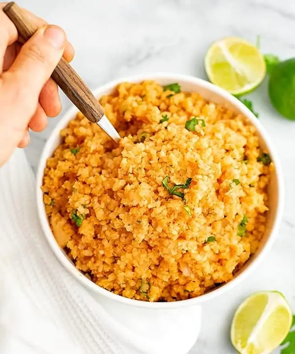 Wooden spoon in a bowl of Mexican Cauliflower Rice.