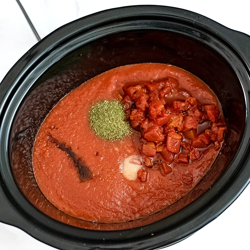 Slow cooker filled with Whole30 Marinara ingredients.