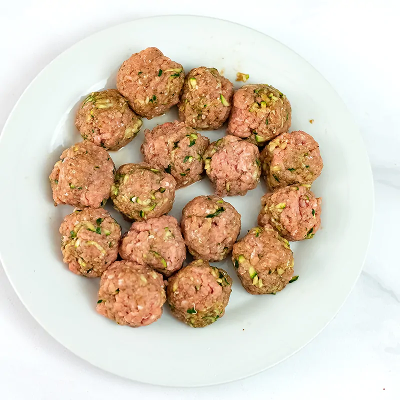 Whole30 Turkey meatballs formed before cooking on a white plate
