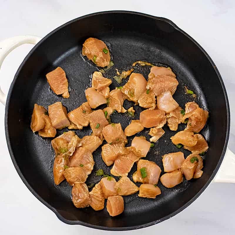 Raw Asian chicken in cast iron skillet before cooking.
