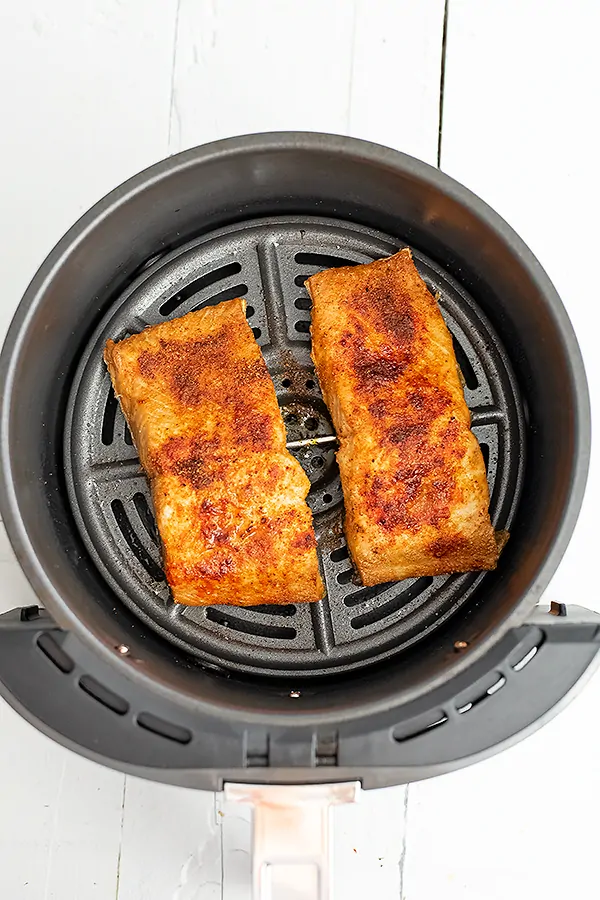 Salmon in air fryer basket after cooking.