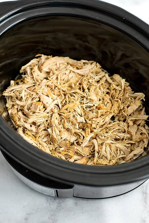 Slow cooker filled with crockpot ranch chicken after shredding.