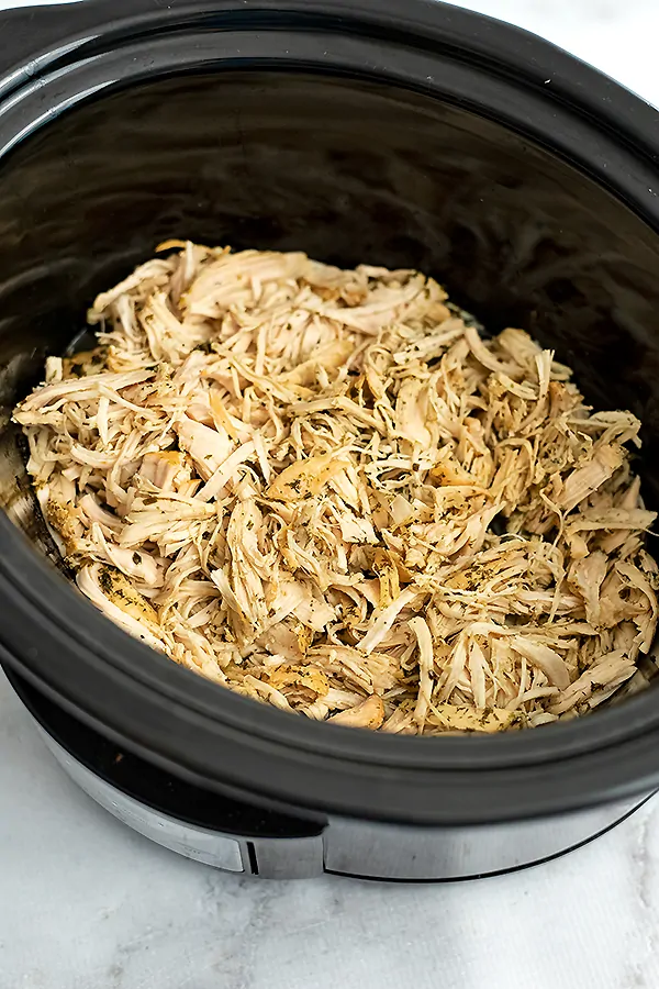 Slow cooker filled with crockpot ranch chicken after shredding.