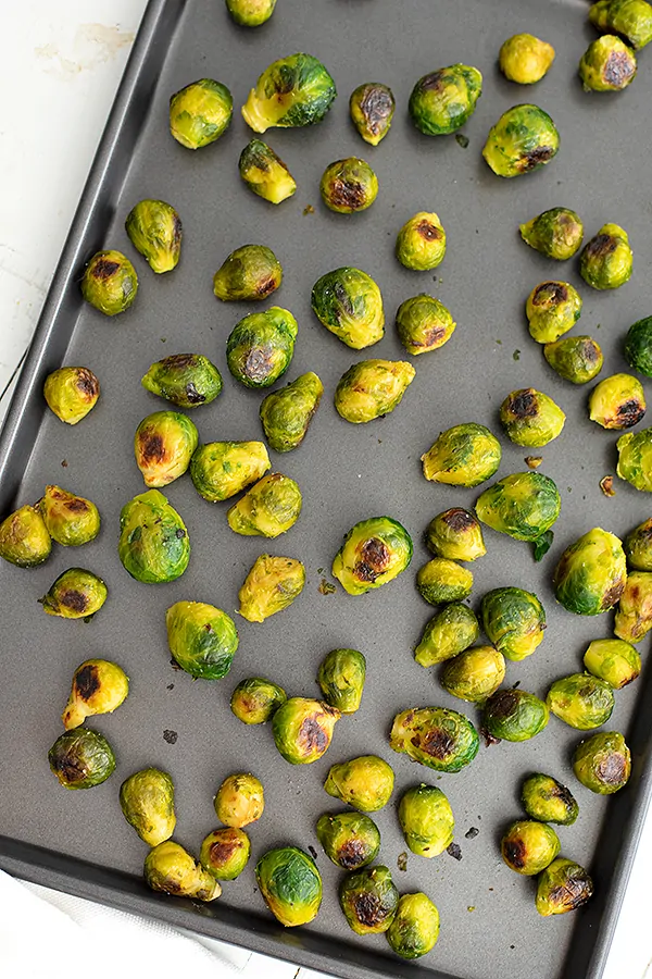 Roasted brussel sprouts on a baking sheet after roasting.