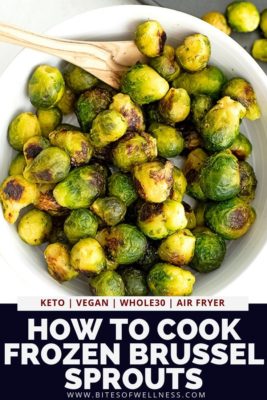 Large bowl filled with roasted brussel sprouts and a wooden spoon.