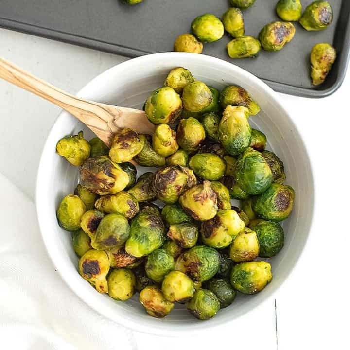 White bowl filled with roasted frozen brussel sprouts.