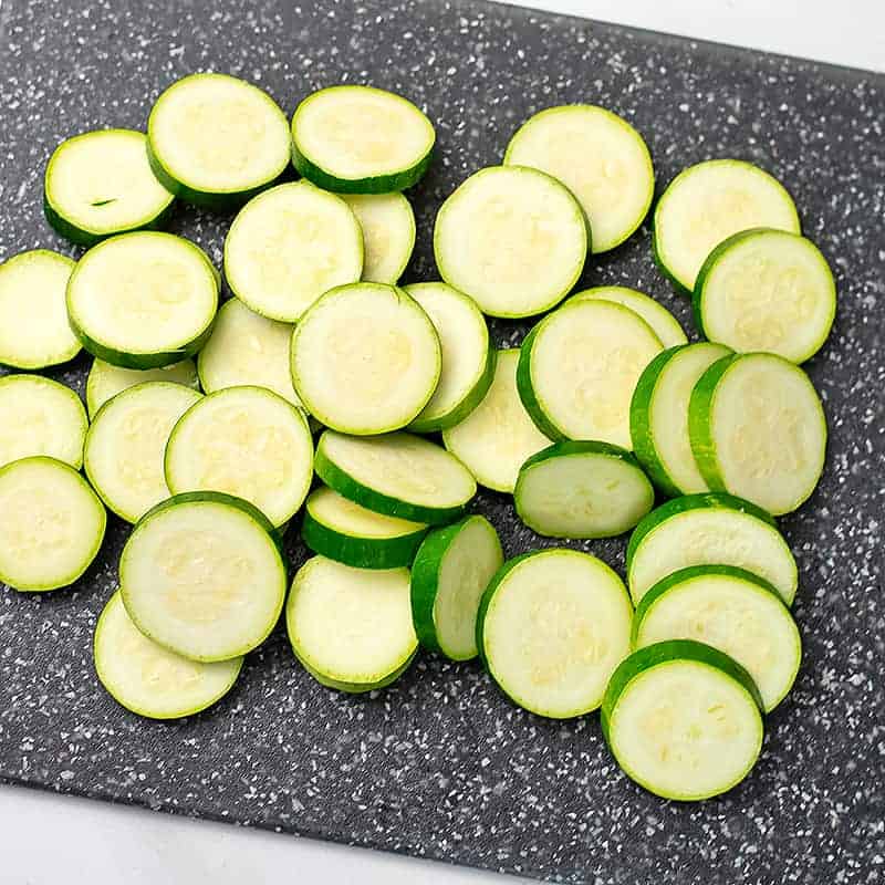 Zucchini cut into coins on a cutting board. 