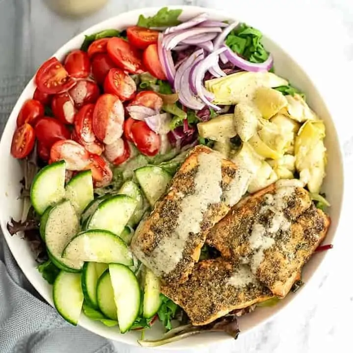 Large bowl of Italian Salmon Salad with dressing poured on top.