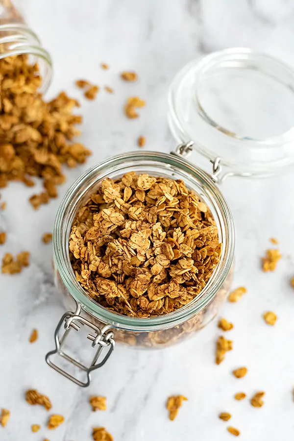 Glass jar filled with vegan granola clusters.