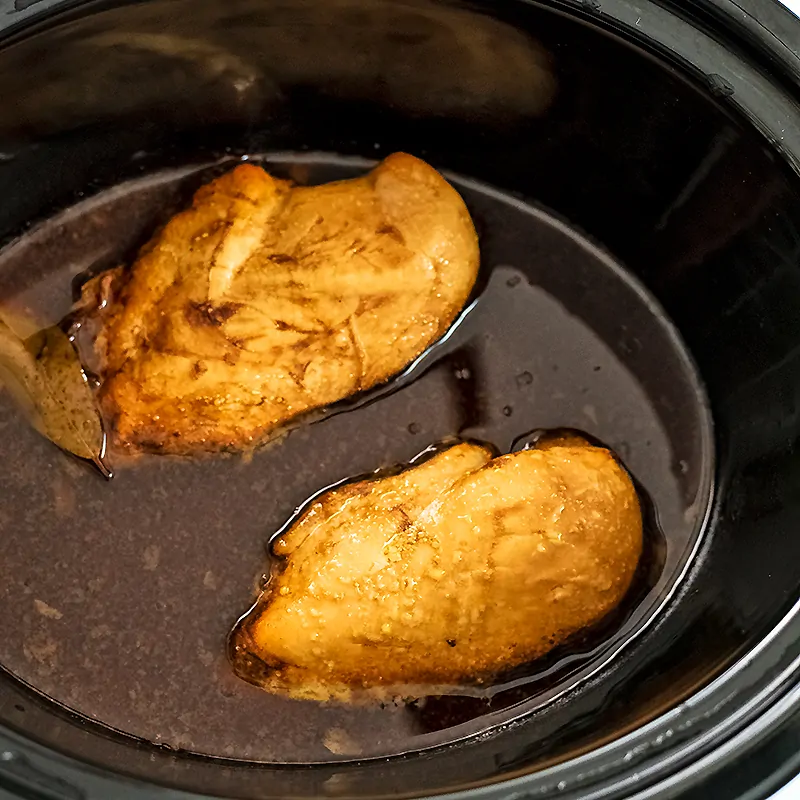 Cooked balsamic chicken in the crock pot before shredding.