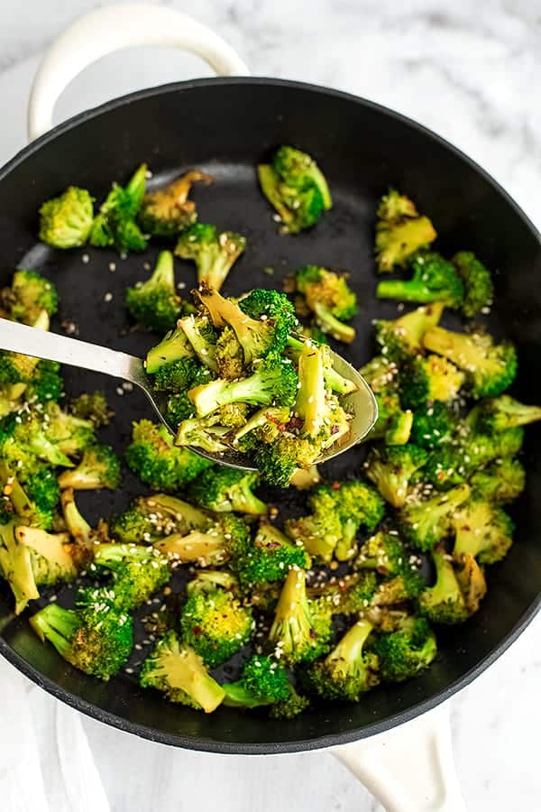 Cast iron skillet filled with sesame Asian broccoli.